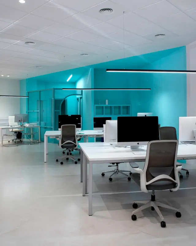 Zona de trabajo con suelo de microcemento continuo y pared en verde turquesa
