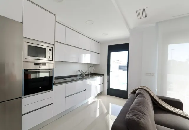 Cocina y salón con paredes lisas en blanco mate