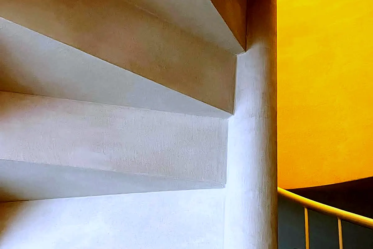Cara inferior de la escalera de microcemento con luz cálida lateral